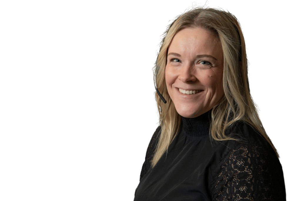 Smiling blonde woman wearing a headset microphone and a black lace top against a solid green background.